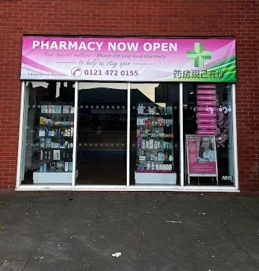 Selly Pharmacy storefront on Bristol Road, Selly Oak, Birmingham — pink and green 'Pharmacy Now Open' banner above the entrance