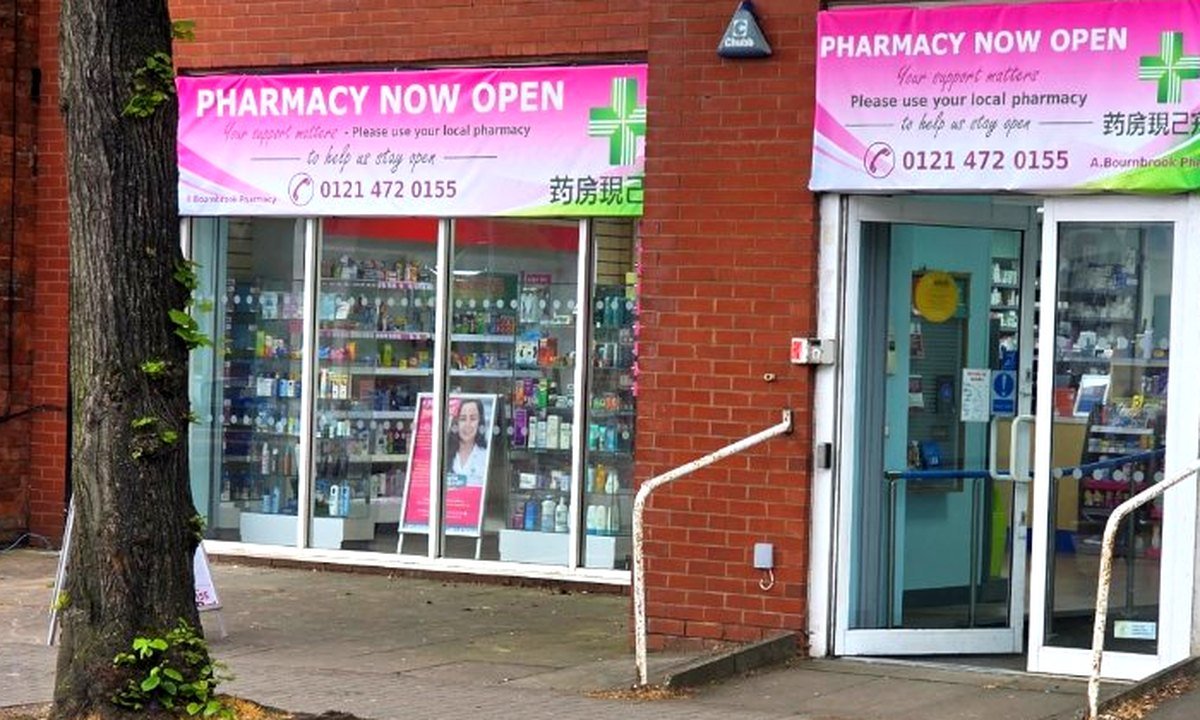 Selly Pharmacy on Bristol Road in Selly Oak, Birmingham — wider exterior shot showing both shopfronts with the 'Pharmacy Now Open' banners and the entrance